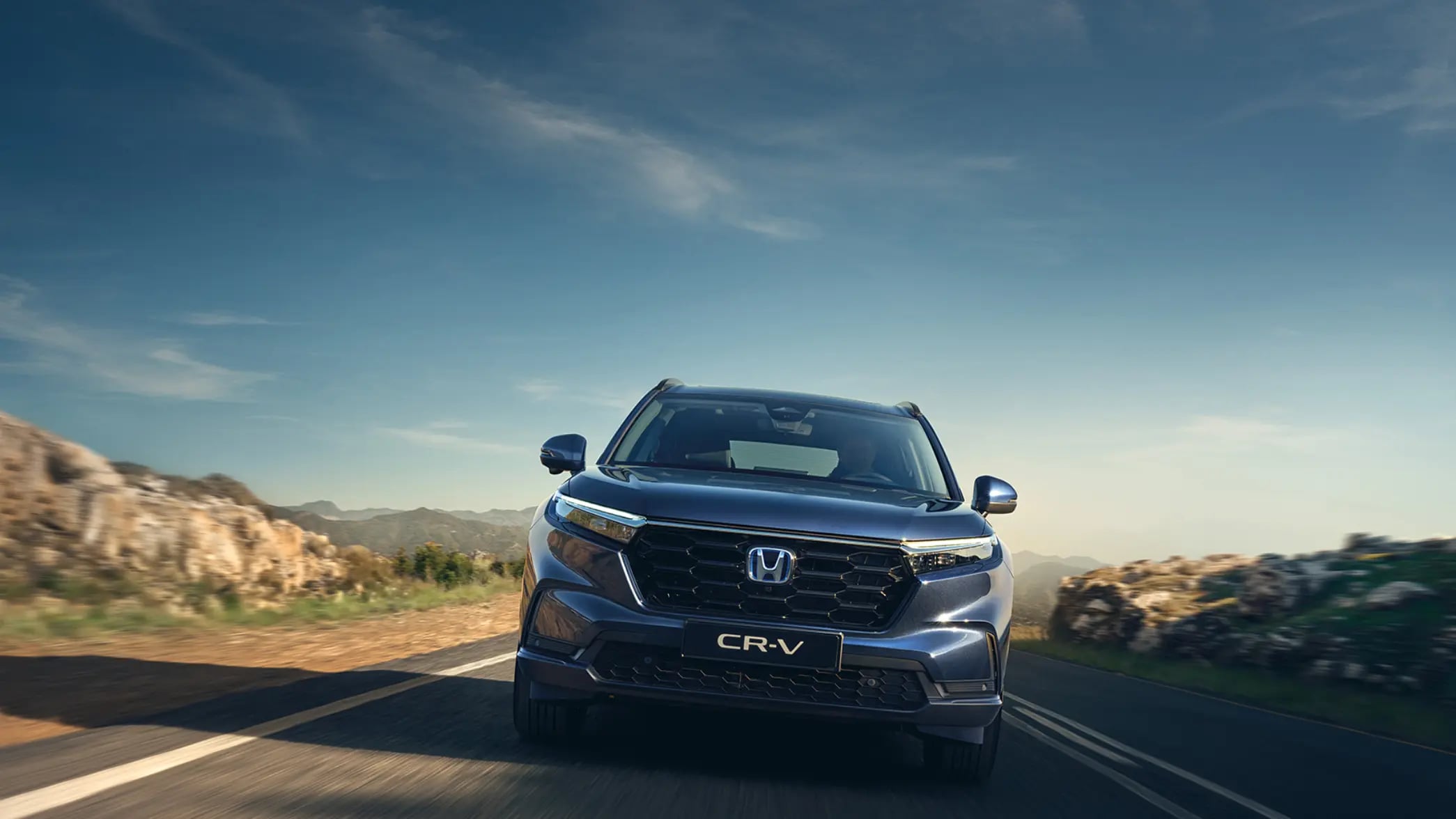 Detailný záber na koleso a bok zaparkovaného vozidla CR-V Hybrid SUV, s figurantom.